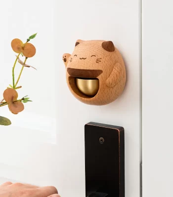 A charming wooden doorbell featuring a lucky cat design